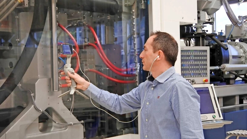 Kameramann: Peter Schmid, Teamleiter Anwendungen, überträgt mit einer Handykamera die Produktion der Verschlussdeckel in alle Welt.