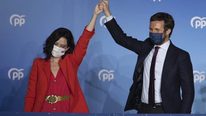 Isabel DÌaz Ayuso (l), Spitzenkandidatin der konservativen Volkspartei (PP), und Pablo Casado (r), Vorsitzender der Partei, feiern den Wahlsieg. Foto: Bernat Armangue/AP/dpa