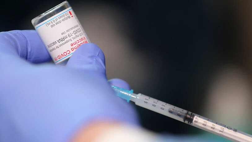 Ein Arzt zieht eine Spritze mit dem Impfstoff von Moderna auf. Foto: Oliver Berg/dpa