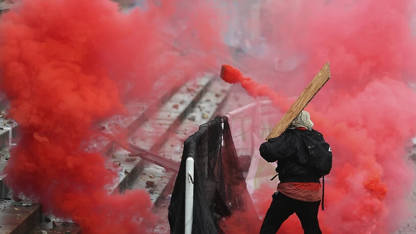 Ein regierungskritischer Demonstrant wirft einen Tränengaskanister zurück. Foto: Fernando Vergara/AP/dpa