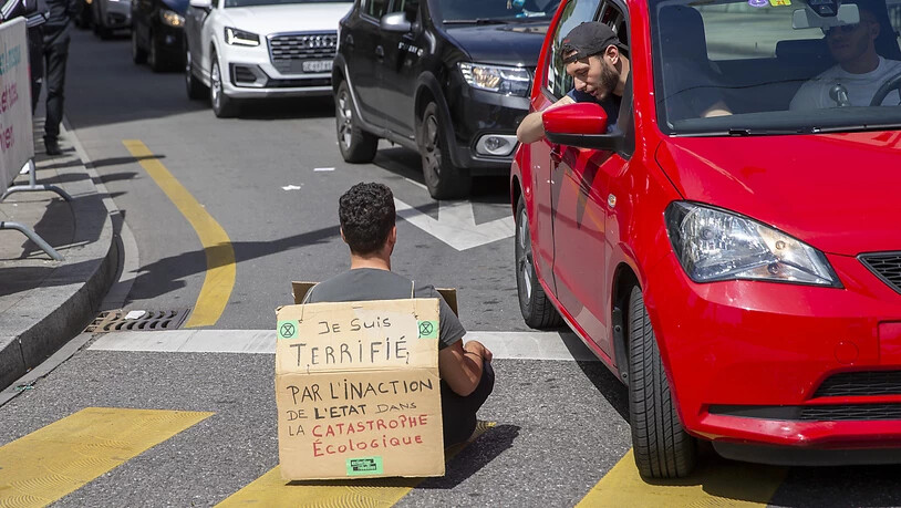 "Ich bin entsetzt über die Untätigkeit des Staates in der ökologischen Katastrophe", stand auf dem Plakat eines Aktivisten, der sich am Samstag in Genf auf die Strasse setzte.