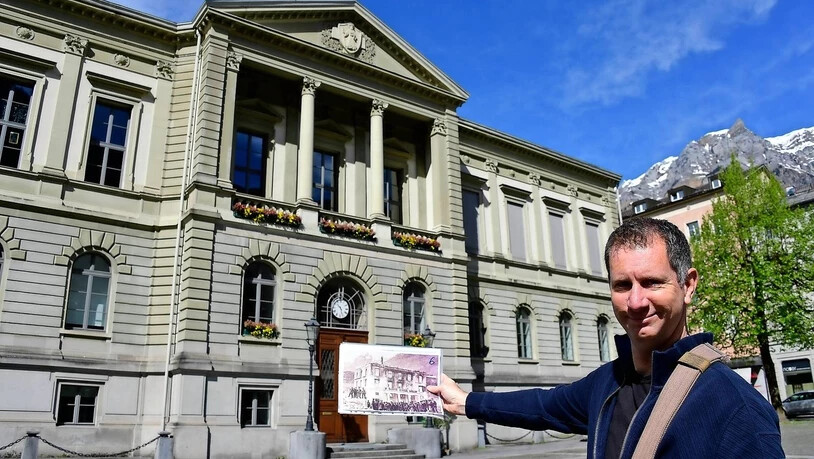 Neues Rathaus: Rolf Kamm zeigt eine Aufnahme des ausgebrannten Regierungsgebäudes. Es wurde am gleichen Ort durch das jetzige Rathaus ersetzt.