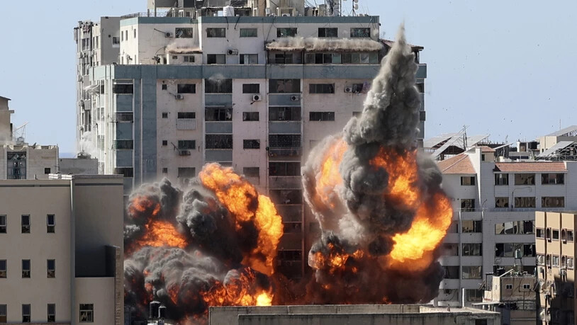 dpatopbilder - Rauch und Feuer steigen aus einem Gebäude nach einem israelischen Luftangriff auf. In dem Gebäude sind verschiedene internationale Medien untergebracht, darunter auch die Associated Press und Al-Dschasira. Foto: Mahmud Hams/POOL AFP/AP/dpa