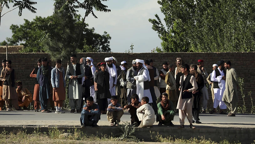 Menschen versammeln sich in der Nähe einer Moschee nach einer Bombenexplosion in Kabul. Bei dem Anschlag sind nach Angaben der Polizei mindestens zwölf Menschen getötet worden. Foto: Rahmat Gul/AP/dpa