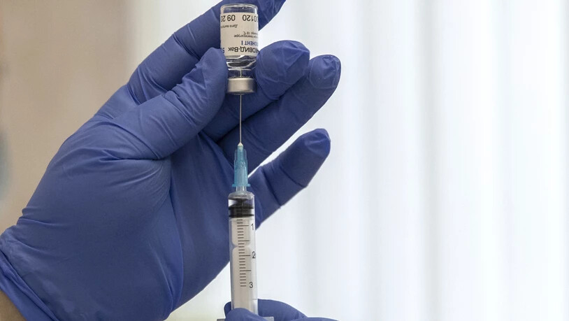 ARCHIV - Ein medizinischer Mitarbeiter bereitet eine Spritze mit dem in Russland entwickelten Corona-Impfstoff «Sputnik V» vor. In Moskau wächst die Sorge vor deutlich steigenden Corona-Infektionszahlen. Umfragen sehen eine große Impfmüdigkeit in…