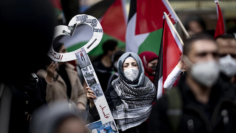 15.05.2021, Berlin: Eine Teilnehmerin der Demonstration verschiedener palästinensischer Gruppen läuft durch Neukölln. Zum jährlichen Gedenktag Nakba am 15. Mai erinnern Palästinenser an die Flucht und Vertreibung von Hunderttausenden Palästinensern aus…