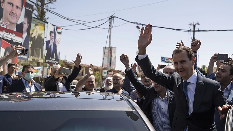 Baschar al-Assad (r), Präsident von Syrien, kommt an einem Wahllokal während der Präsidentschaftswahlen an. Foto: Hassan Ammar/AP/dpa