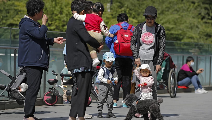 ARCHIV - Anwohner bringen ihre Kinder zum Spielen auf ein Gelände in der Nähe eines kommerziellen Bürogebäudes. China lockert seine Familienpolitik und erlaubt Paaren künftig drei Kinder. Foto: Andy Wong/AP/dpa Foto: Andy Wong/AP/dpa