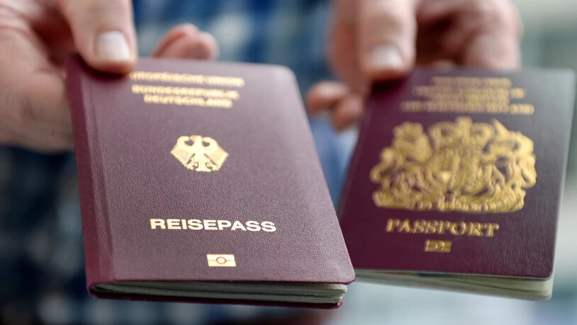 ARCHIV - Ein britischer und ein deutscher Reisepass werden in die Kamera gehalten. Foto: Britta Pedersen/zb/dpa