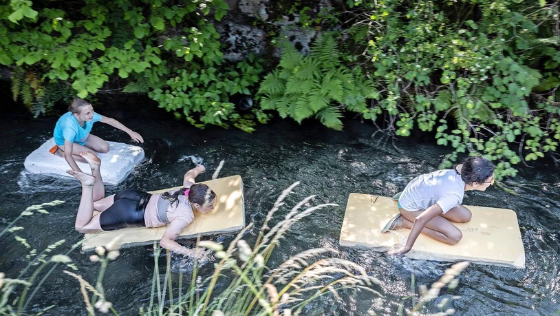Welch ein Spass im Juni: Drei Mädchen geniessen das Prachtwetter auf dem Rütelibach in Mollis und lassen sich auf Styroporplatten flussabwärts treiben