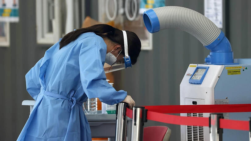 Eine medizinische Mitarbeiterin einer Corona-Teststation steht in Seoul vor einem Luftkühler. Zuletzt wurden im Land 826 neue Infektionen gemeldet, der höchste Wert seit fast sechs Monaten. Foto: --/YNA/dpa