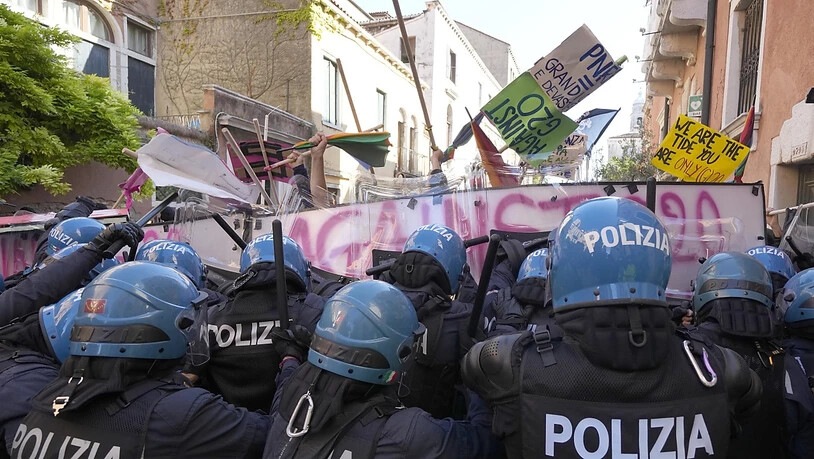 Demonstranten gegen den G20-Gipfel der Wirtschafts- und Finanzminister und italienische Polizisten stehen sich gegenüber. Foto: Luca Bruno/AP/dpa