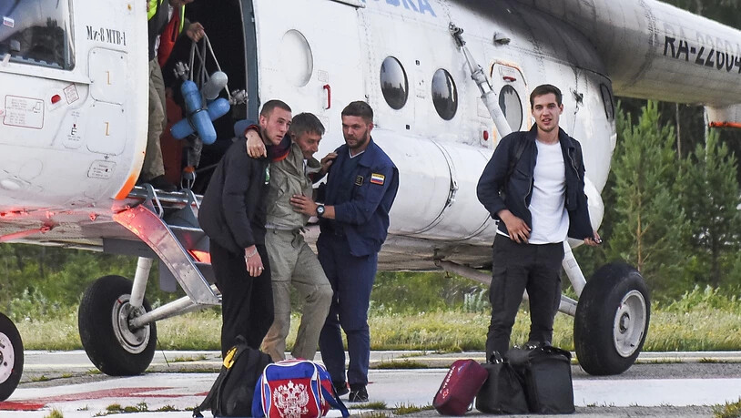 Der Pilot Anatolij Prytkow (M) wird nach der Notlandung eines kleineren Passagierflugzeugs mit 18 Menschen an Bord von seinen Kollegen gestützt. Laut Angaben des Ermittlungskomitees könnte ein Ausfall beider Triebwerke die Ursache der Bruchlandung im…