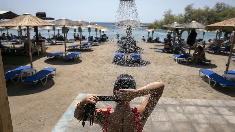 Eine Frau duscht an einem Strand des Dorfes Lagonissi, einige Kilometer südwestlich von Athen. Eine der schwersten Hitzewellen seit den 1980er Jahren ist über Südosteuropa hereingebrochen. In Teilen Griechenlands steigen die Temperaturen auf über 40 Grad…