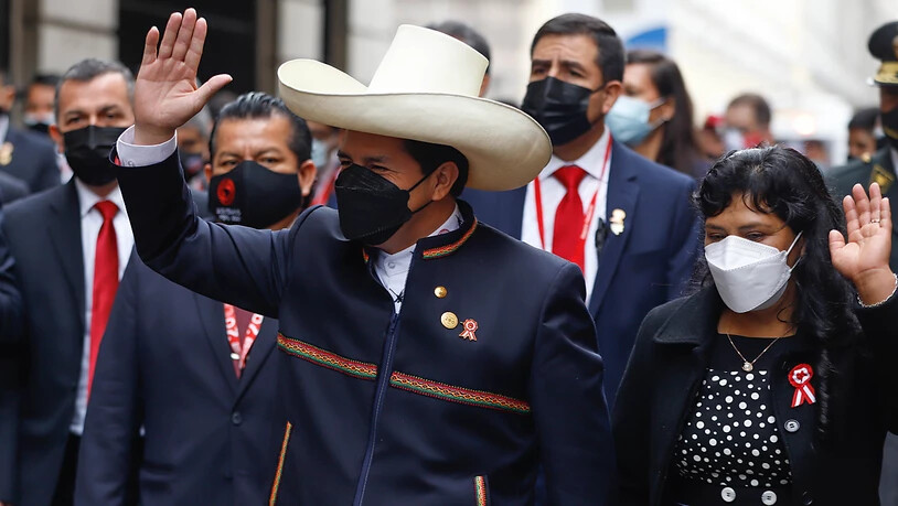 HANDOUT - Auf diesem vom peruanischen Präsidentenamt zur Verfügung gestellten Bild gehen Pedro Castillo (M.) und seine Frau Lilia Paredes zum Parlament am Tag seiner Amtseinführung als neuen Präsidenten. Der 51-Jährige legte am Mittwoch im Kongress in…