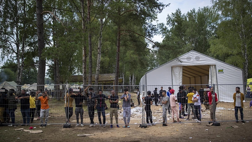 Geflüchtete stehen hinter einem Zaun des neu errichteten Flüchtlingslagers auf dem Truppenübungsplatz Rudninkai, etwa 38 km südlich von Vilnius. Das Rote Kreuz kritisierte die Entscheidung der litauischen Regierung, Migranten aus Belarus abzuweisen und…