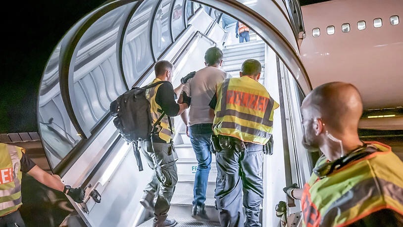 ARCHIV - Polizeibeamte begleiten einen Afghanen auf dem Flughafen Leipzig-Halle in ein Charterflugzeug. Die EU-Botschafter in Afghanistan raten angesichts des schnellen Vormarsches der Taliban von Abschiebungen in das Krisenland vorerst ab, heißt es in…