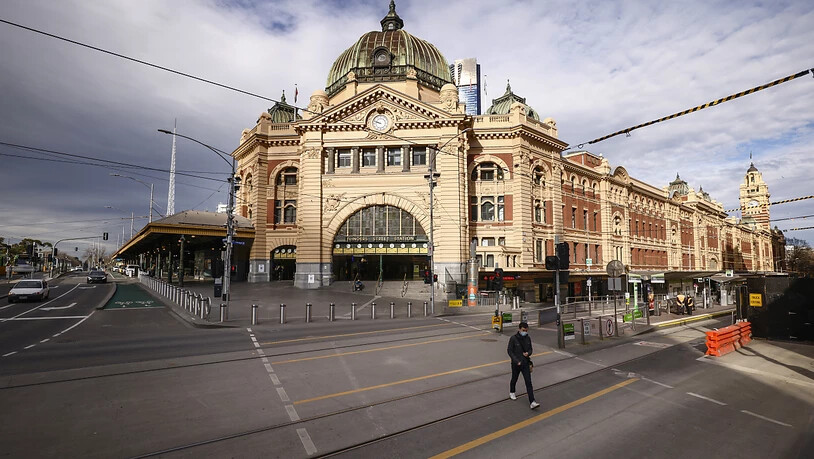A lone person crosses a quiet Flinders Street in Melbourne, Wednesday, August 11, 2021. Regional Victoria's lockdown is over but people in Melbourne are still days from finding out when theirs will end.  (AAP Image/Daniel Pockett) NO ARCHIVING