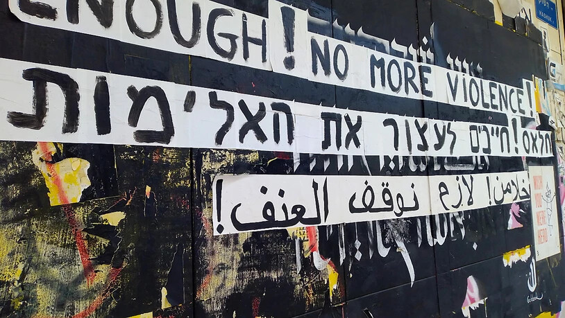 Graffiti gegen die Gewalt zwischen Juden und Arabern an einer Hauswand in englischer, hebräischer und arabischer Sprache. Zwei Rapper haben nach Ausschreitungen im Mai mit einem viral gegangenen Song die wechselseitigen Vorurteile thematisiert. Foto: Eva…