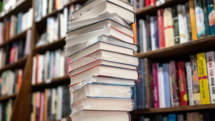 ARCHIV - Ein Stapel neuer Bücher liegt auf einem Verkaufstisch in einer Buchhandlung im Stadtteil Bornheim. Was sind die preisverdächtigsten Romane des Jahres? Der Börsenverein des Deutschen Buchhandels hat die sogenannte Longlist für den Deutschen…