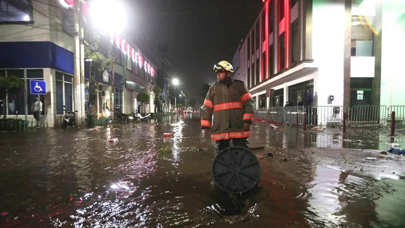 Ein Feuerwehrmann steht in einer überfluteten Straße in Ecatepec. Aufgrund starker Regenfälle am Montag kam es im Zentrum von Ecatepec im Bundesstaat Mexiko zu Überschwemmungen. Foto: El Universal/El Universal via ZUMA Press Wire/dpa