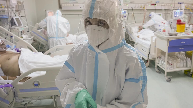 Eine medizinische Mitarbeiterin richtet ihre Handschuhe auf der Corona-Intensivstation. Foto: Vadim Ghirda/AP/dpa