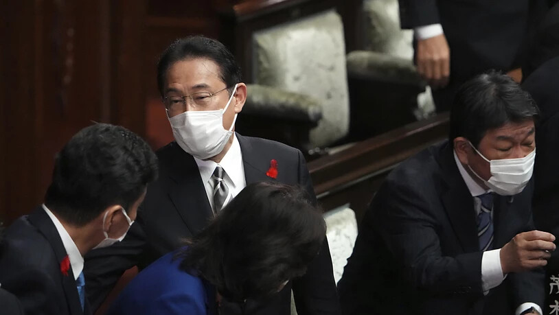 Japans Premierminister Fumio Kishida (M) und andere Abgeordnete sprechen nach der Auflösung des Unterhauses während einer außerordentlichen Sitzung des Parlaments. Foto: Eugene Hoshiko/AP/dpa