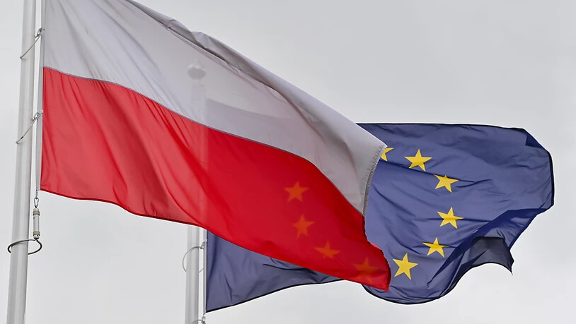 ARCHIV - Die weiß-rote Nationalfahne Polens und dahinter die Fahne der Europäischen Union (EU) wehen im Wind. Foto: Patrick Pleul/dpa-Zentralbild/ZB
