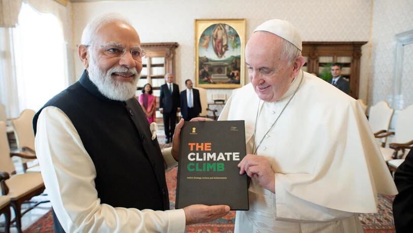 HANDOUT - Narendra Modi, Premierminister von Indien, überreicht Papst Franziskus ein Buch zur Klimastrategie Indiens während eines Treffens im Vatikan. Nach dem Treffen reist Modi weiter zum UN-Klimagipfel COP26, der an diesem Sonntag (31.10.2021) in…