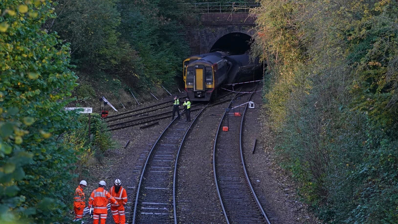 Polizisten und Rettungskräfte arbeiten am Unfallort mit zwei Zügen in der Nähe des Fisherton-Tunnels zwischen Andover und Salisbury. Mehre Menschen sind mit leichten Verletzungen in Krankenhäusern gebracht worden. Foto: Steve Parsons/PA Wire/dpa