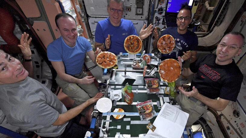 HANDOUT - Die Astronauten Marke Vande Hei aus den USA (l-r), Sergei Rjasanski aus Russland, Paolo Nespoli aus Italien, Joe Acaba aus den USA und Randy Bresnik aus den USA, essen auf der Internationalen Raumstation ISS ihre selbstgemachten Pizzen. Foto:…