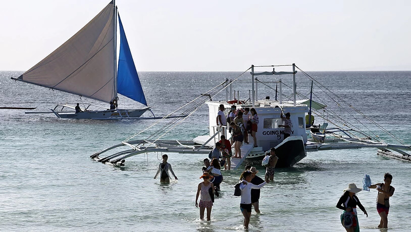 ARCHIV - Eine Gruppe von Touristen kommt am Strand von Boracay an. Die Philippinen werden bald wieder ihre Grenzen für vollständig geimpfte Urlauber aus «grünen» Ländern mit einer hohen Impfquote und niedrigen Infektionszahlen öffnen. Das teilte der…