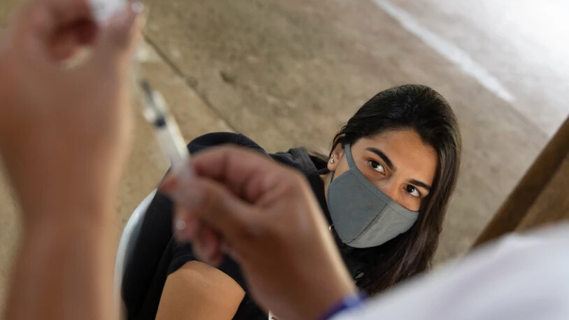 GRAFIK - Eine medizinische Helferin bereitet auf der Insel Ilha de Paqueta die Impfung einer jungen Frau (r) gegen Covid-19 vor. Ab Mitte November 2021 bietet Brasilien allen Menschen ab 18 Jahren künftig eine Verstärkungsimpfung gegen das Coronavirus an…