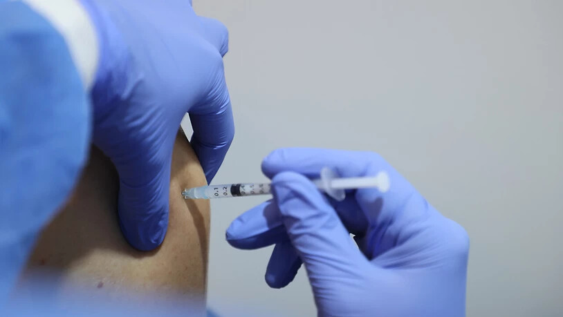 Ein medizinischer Mitarbeiter impft einen Mann mit dem Impfstoff von Biontech. Foto: Bodo Schackow/dpa-zentralbild/dpa