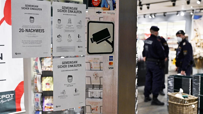 Hinweisschilder sind neben dem Eingang eines Geschäfts in Wien angebracht, die Informationen darüber geben, dass nur Personen mit einem 2G-Nachweis, Personen die vom Coronavirus genesen oder geimpft sind, in diesem Laden einkaufen dürfen. Foto: Hans Punz…