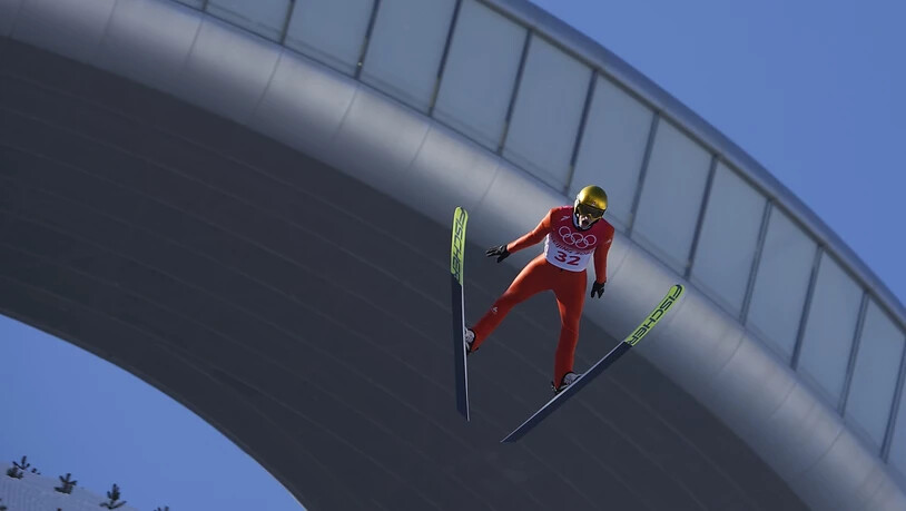 Gregor Deschwanden schwebt runter in den Kessel. Obwohl die Flaggen stramm im Wind stehen, kann auf dieser Anlage gesprungen werden.