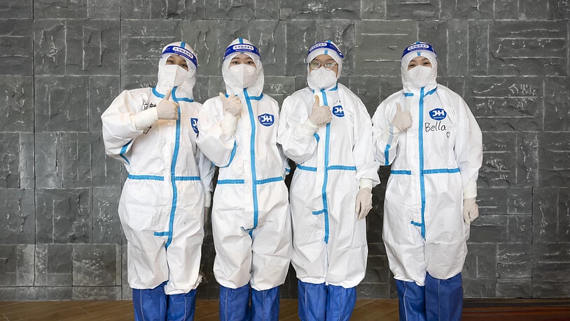 Hotel-Mitarbeiter strecken den Daumen hoch: Hinter den maskierten Helfern in Peking verstecken sich engagierte und freundliche Mitarbeitende