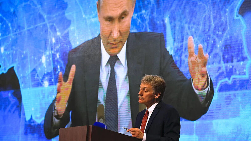 ARCHIV - Wladimir Putin spricht bei  einer Pressekonferenz per Video zu Medienvertretern, Kremlsprecher Dmitri Peskow hört zu. Foto: Alexander Zemlianichenko/AP/dpa