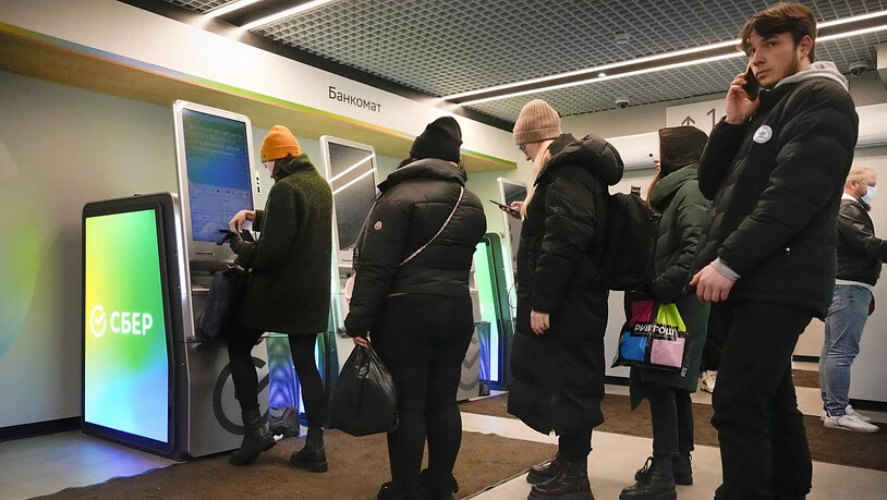 Menschen in St. Petersburg heben Geld von ihren Konten bei der von Sanktionen betroffenen Sberbank ab. Die Schweizer Tochtergesellschaft der russischen Grossbank meldet, bei ihr gehe die Arbeit weiter.
