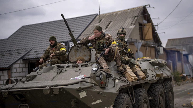 Ukrainische Soldaten fahren auf einem gepanzerten Militärfahrzeug in den Außenbezirken von Kiew, Ukraine. Russische Truppen marschierten am 24. Februar in die Ukraine ein. Foto: Emilio Morenatti/AP/dpa