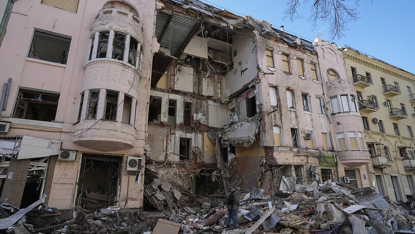 Ein Mann geht an einem zerstörten Gebäude nach einem russischen Angriff in Charkiw vorbei. Foto: Efrem Lukatsky/AP/dpa