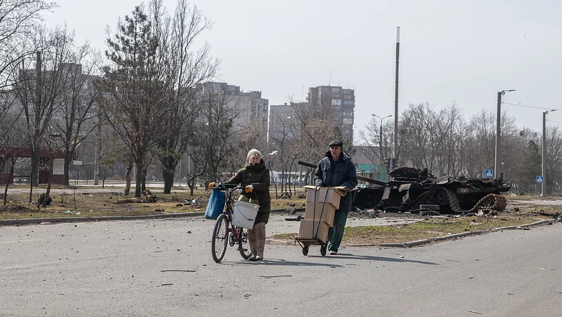 Ein Paar geht an einem zerstörten Panzer im Stadtzentrum vorbei. Die prorussischen Separatisten in der Ostukraine haben Angaben des Sprechers der prorussischen Kräfte im Gebiet Donezk, Eduard Bassurin, zufolge weitgehend die Kontrolle über das…