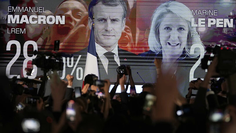 dpatopbilder - Ein Bildschirm zeigt den französischen Präsidenten Macron und die rechtsextreme Kandidatin Le Pen am Wahltag. Foto: Francois Mori/AP/dpa