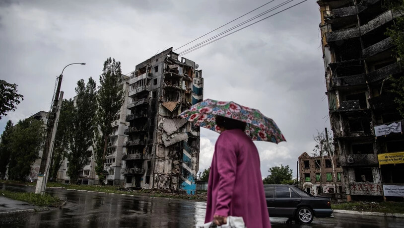 Eine Frau geht an durch Luftangriffe zerstörten Wohnhäusern an der Zentralstraße in Borodianka vorbei. Foto: Michal Burza/ZUMA Press Wire/dpa