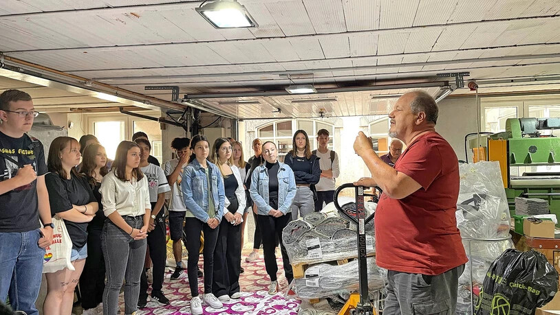 Bei der Swiss Mountain Händ Bägs: Geschäftsleiter Eugène Fauqeux führt die Schülerinnen und Schüler in Engi durch den Betrieb. 