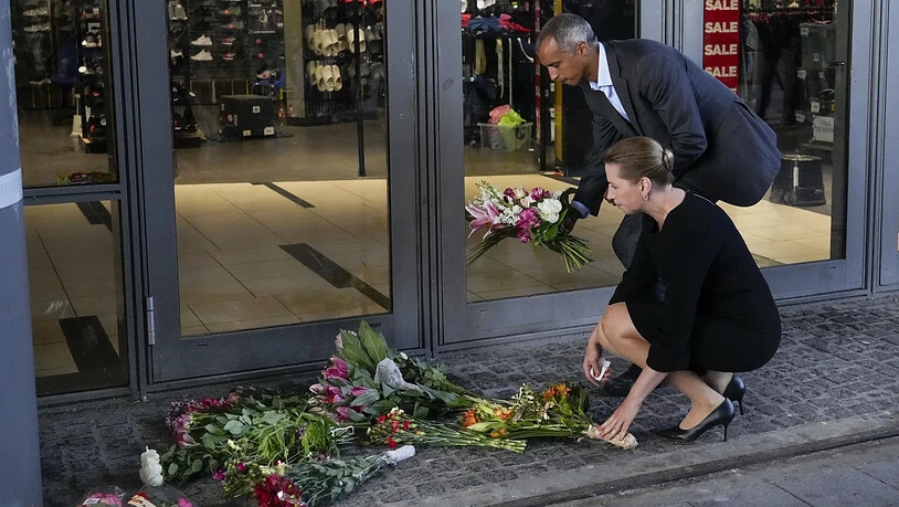 Mette Frederiksen, Ministerpräsidentin von Dänemark, und Mattias Tesfaye, Justizminister von Dänemark, legen Blumen am Eingang des Einkaufszentrums Field's nieder. Foto: Sergei Grits/AP/dpa