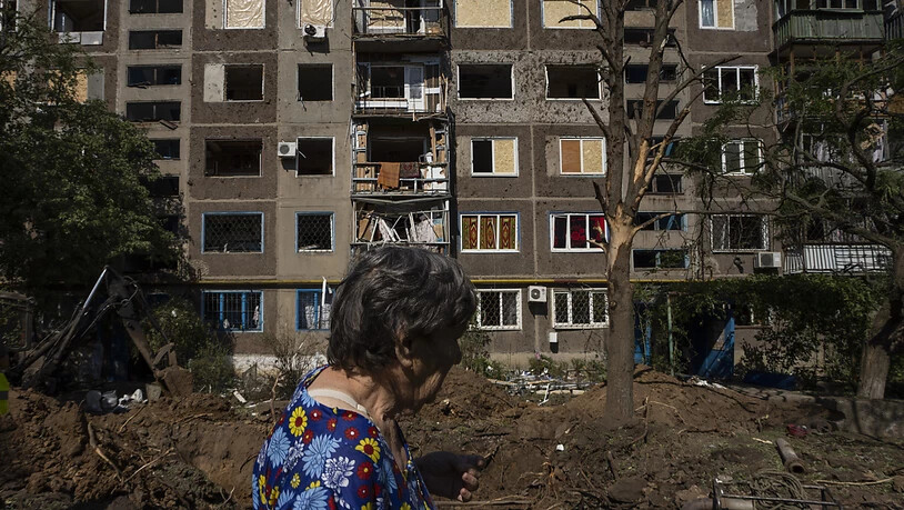 Eine Frau geht an einem beschädigten Gebäude nach einem Raketeneinschlag in Kostjantyniwka im Gebiet Donezk vorbei. Foto: Nariman El-Mofty/AP/dpa