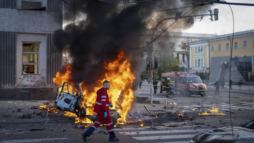 Ein Sanitäter geht nach einem russischen Angriff auf Kiew an einem brennenden Auto vorbei. Foto: Roman Hrytsyna/AP/dpa