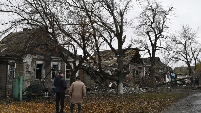 Menschen stehen vor zerstörten Wohnhäusern in Pokrowsk. Foto: Andriy Andriyenko/AP/dpa