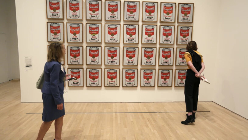 ARCHIV - Zwei Frauen betrachten das Pop-Art-Kunstwerk "Campbell's Soup Cans" von 1962 in der Ausstellung "Andy Warhol - From A to B and Back Again" in San Francisco. Foto: Eric Risberg/AP/dpa - ACHTUNG: Nur zur redaktionellen Verwendung im Zusammenhang…